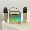 A karaoke speaker and two microphones are displayed on a white surface. Produktbild-Vorschau