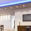A modern living room with recessed lighting and a TV. Náhled obrázku produktu