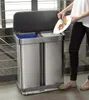 A person is throwing food scraps from a plate into a dual-compartment trash can. Podgląd zdjęcia produktu