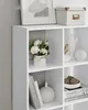 A close-up shot of a white modular shelving unit with various decorative items placed in its compartments. Náhled obrázku produktu