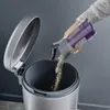 A hand is emptying a vacuum cleaner dustbin into a trash can. Náhled obrázku produktu