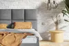 A bedroom setting with a bed and side table. Náhled obrázku produktu