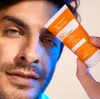 A close-up shot of a man holding a tube of sunscreen. Náhled obrázku produktu