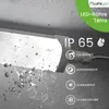 A close-up of a white LED light fixture with debris falling around it, set against a textured gray background. Text and icons indicating product features are overlaid on the right side. Produktbild-Vorschau