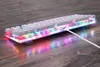 A white mechanical gaming keyboard with RGB lighting is placed on a wooden surface. Produktbild-Vorschau
