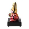 A side view of a colorful ceramic rabbit figurine sitting on a black base. Produktbild-Vorschau