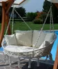 A double hanging lounge chair with cushions is shown outdoors, next to a swimming pool. Produktbild-Vorschau