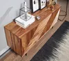 A wooden sideboard with decorative carvings, placed on a wooden floor next to a rug and a wall. Náhled obrázku produktu