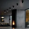 A modern living room with concrete walls, a fireplace, and a sofa. Náhled obrázku produktu