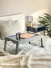 A bedside table with a lamp and a tray on a bed with a fluffy blanket. Produktbild-Vorschau