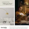 A woman reading a book in a cozy living room setting, illuminated by a stylish arc lamp. Náhled obrázku produktu