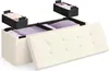 A storage ottoman with its lid open, revealing storage compartments and folded linens. Two smaller storage boxes are shown suspended above the ottoman. Produktbild-Vorschau