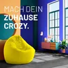 A bright and modern living room scene with a yellow beanbag chair in the foreground and colorful walls and furniture in the background. Produktbild-Vorschau