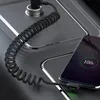 A coiled charging cable connects a car charger to a smartphone that is fully charged. Anteprima dell’immagine prodotto