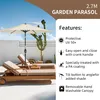 A cream-colored garden parasol is set up next to two lounge chairs on a patio. Voir les images du produit
