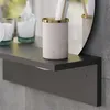 A close-up view of a bathroom shelf with a toothbrush holder and bottles. Produktbild-Vorschau