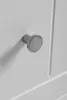 A close-up shot of a silver cabinet knob on a white cabinet door. Anteprima dell’immagine prodotto