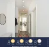 A modern hallway with three ceiling lights, a mirror, a bench, and a rug. The bottom of the image shows a diagram illustrating different lighting modes. Produktbild-Vorschau