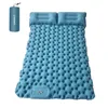 A blue inflatable camping mattress with two built-in pillows, shown inflated and laid out flat. A rolled-up blue carrying bag for the mattress is shown in the upper left corner. Náhled obrázku produktu