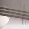 A close-up view of a dark gray fabric blind with text in the background. Produktbild-Vorschau