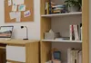A home office setup with a desk, computer, lamp, and a bookshelf filled with books and decorative items. Podgląd zdjęcia produktu