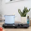 A light blue pot with a wooden spoon sits on a black double hot plate, next to a snake plant in a white pot and a bottle of olive oil. Náhľad obrázku produktu