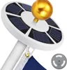 A close-up view of a solar-powered flag pole light, showing its solar panels and golden finial. Produktbild-Vorschau