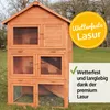 A multi-story wooden rabbit hutch is shown outdoors on a grassy lawn, with trees in the background. There are marketing overlays on the image. Produktbild-Vorschau
