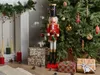A festive Christmas scene with a nutcracker figure, a decorated Christmas tree, wrapped gifts, and candles. Náhľad obrázku produktu