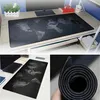 A collage of images showing a large mouse and keyboard mat with a world map design, a close-up of the mat's texture, and a view of the mat on a desk. Náhled obrázku produktu