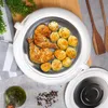 A white insulated thermos bowl filled with roasted chicken and potatoes, placed on a wooden board with a grey striped cloth and a bottle of olive oil nearby. Produktbild-Vorschau