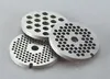 Three metal grinder plates with different hole sizes are stacked on a light gray surface. Podgląd zdjęcia produktu
