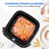 A baking insert with a cake or muffins inside an air fryer basket, with eggs and flour in the background. Produktbild-Vorschau