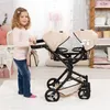 A young girl is standing next to a twin doll stroller in a room. Produktbild-Vorschau