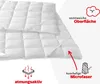 A close-up of a white quilted comforter with various text callouts and icons indicating features. Produktbild-Vorschau
