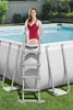 A woman in a red swimsuit is standing on the ladder of an above-ground swimming pool. Produktbild-Vorschau