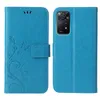 A blue flip cover phone case with a floral and butterfly design on the front cover and a camera cutout on the back cover. Produktbild-Vorschau