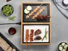 A tabletop grill with food items arranged around it. Produktbild-Vorschau