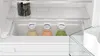 Close-up view inside a refrigerator showing a crisper drawer with three bottles of juice. Voir les images du produit