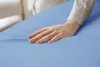 A person's hand is resting on a light blue fabric. Produktbild-Vorschau