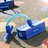 A blue pogo jumper toy is on a playground surface. Produktbild-Vorschau