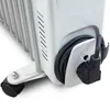 A close-up view of the bottom section of a white oil-filled radiator, showing its wheel and power cord storage. Podgląd zdjęcia produktu