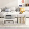 A white coffee table with shelves is placed in front of a sofa in a living room. Náhľad obrázku produktu