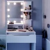 A white vanity table with a lighted mirror and makeup accessories. Náhľad obrázku produktu