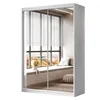 A white sliding door wardrobe with mirrored doors reflecting a window with blinds and a window seat. Produktbild-Vorschau