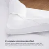 Weiße Matratzenauflage, die eine Matratze teilweise bedeckt, zeigt ihr passgenaues Design und glatte Textur Anteprima dell’immagine prodotto
