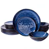 A set of blue ceramic plates and bowls with gold trim, neatly stacked and arranged against a white background. Voir les images du produit