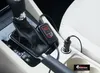 A close-up view of a car's center console, showing a heated seat cover plugged into the cigarette lighter. Produktbild-Vorschau