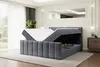 A modern bedroom with a dark gray velvet boxspring bed with its storage compartment open, revealing a mattress and topper. Produktbild-Vorschau