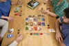 Four people playing the board game Splendor around a wooden table. Produktbild-Vorschau